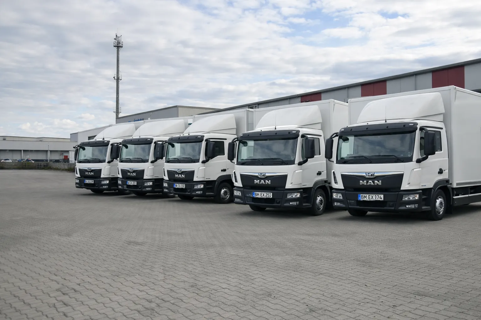Weiße 12-Tonner von Expert Transporte nebeneinander auf dem Hof